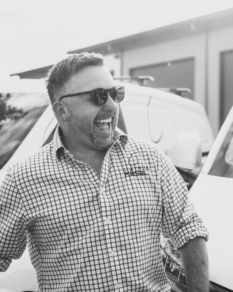 Matt Clayton, Founder and Director of Claymill Construction Services, laughing beside a Claymill van